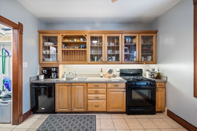 kitchen with light tile patterned floors, a sink, baseboards, black appliances, and glass insert cabinets