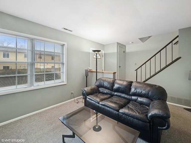 carpeted living area with visible vents, baseboards, and stairs