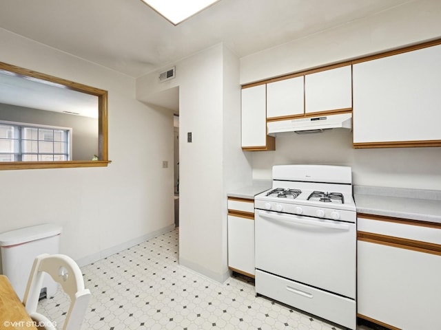 kitchen with white cabinets, white gas stove, visible vents, and under cabinet range hood