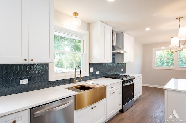 kitchen with decorative backsplash, wall chimney exhaust hood, stainless steel appliances, white cabinetry, and a sink