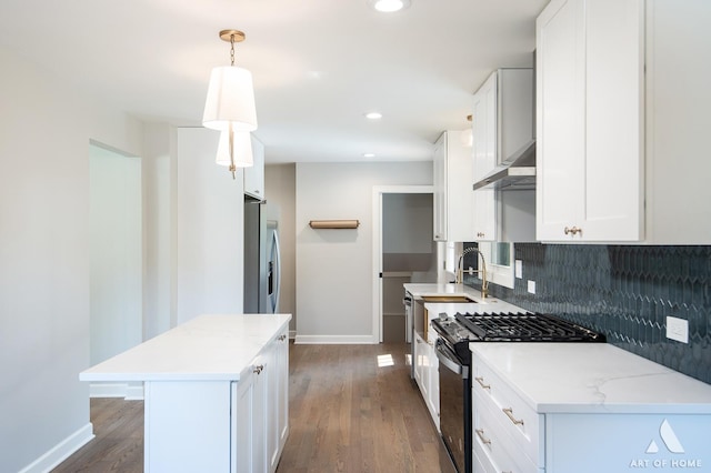 kitchen featuring stainless steel appliances, backsplash, a sink, and dark wood-style flooring