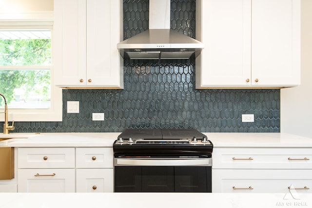 kitchen with white cabinets, wall chimney exhaust hood, decorative backsplash, and gas stove