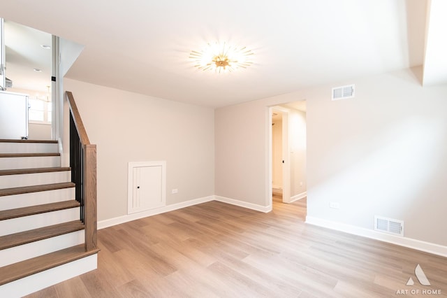 interior space with stairway, baseboards, visible vents, and light wood-style floors