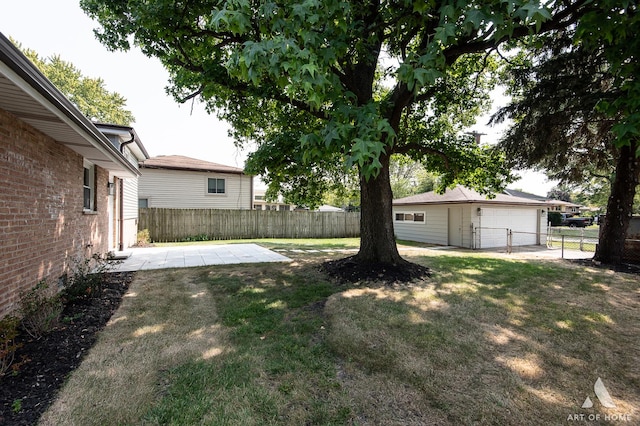 view of yard with a garage, fence, an outdoor structure, and a patio