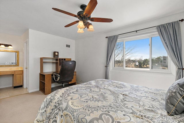 bedroom featuring visible vents, baseboards, light colored carpet, and a ceiling fan