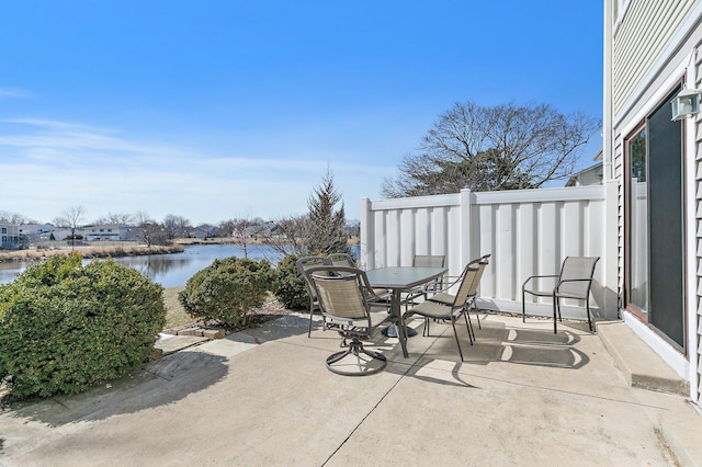 view of patio with outdoor dining area and a water view