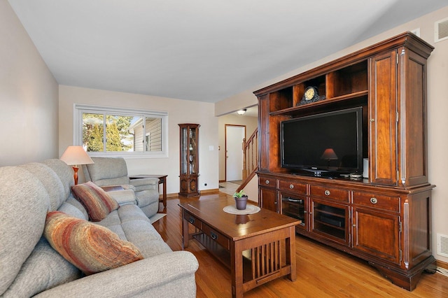 living area featuring light wood-style flooring, baseboards, and visible vents