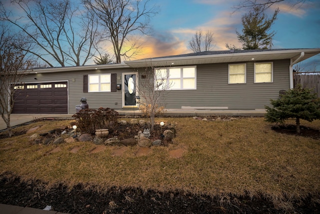 ranch-style house with a garage, driveway, fence, and a front yard