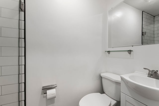 full bathroom featuring a shower, vanity, and toilet