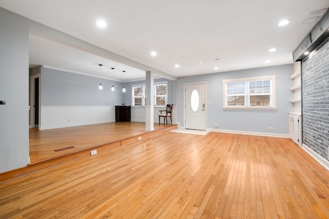 unfurnished living room featuring recessed lighting, visible vents, baseboards, ornamental molding, and light wood finished floors