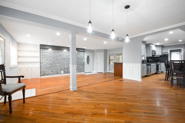 interior space with light wood-style floors, ornamental molding, and recessed lighting