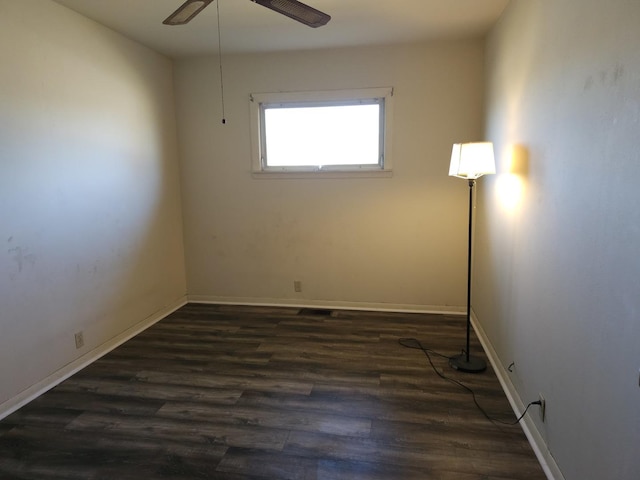 spare room with baseboards, wood finished floors, and a ceiling fan