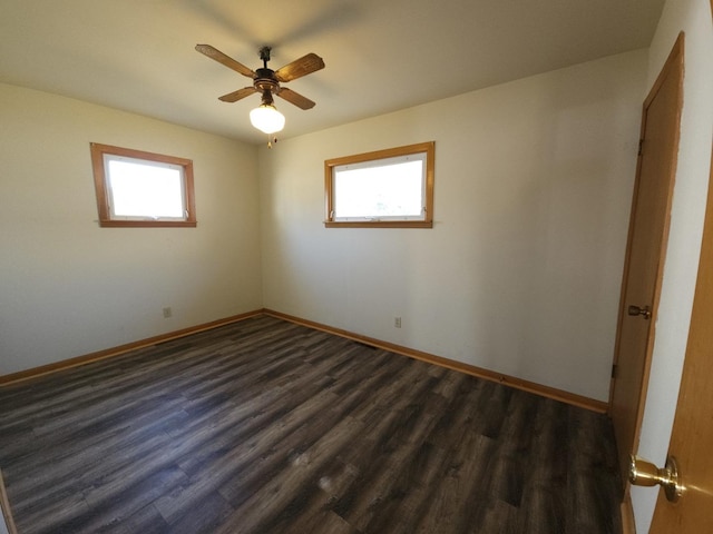 spare room featuring plenty of natural light, dark wood-style floors, and ceiling fan