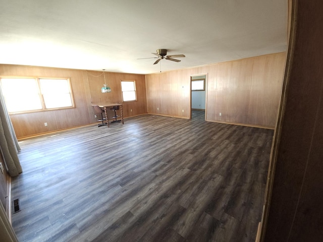 spare room featuring baseboards, dark wood-style floors, and ceiling fan