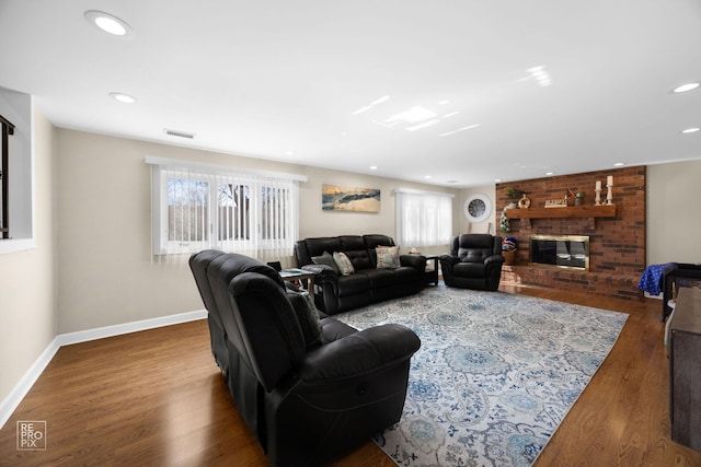 living area featuring baseboards, visible vents, wood finished floors, a fireplace, and recessed lighting