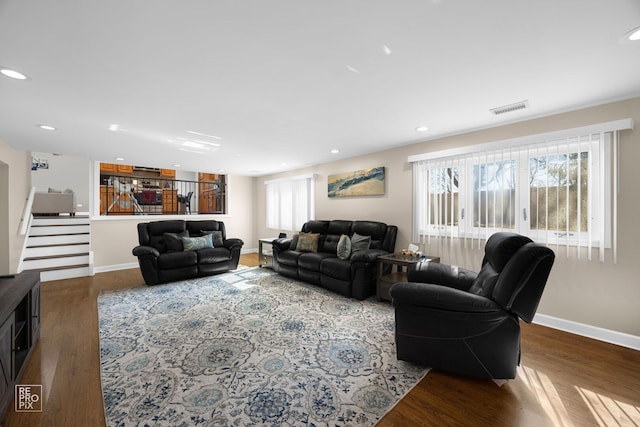 living room with recessed lighting, dark wood-type flooring, visible vents, baseboards, and stairs