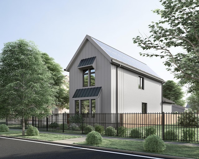 view of home's exterior featuring board and batten siding, metal roof, and fence