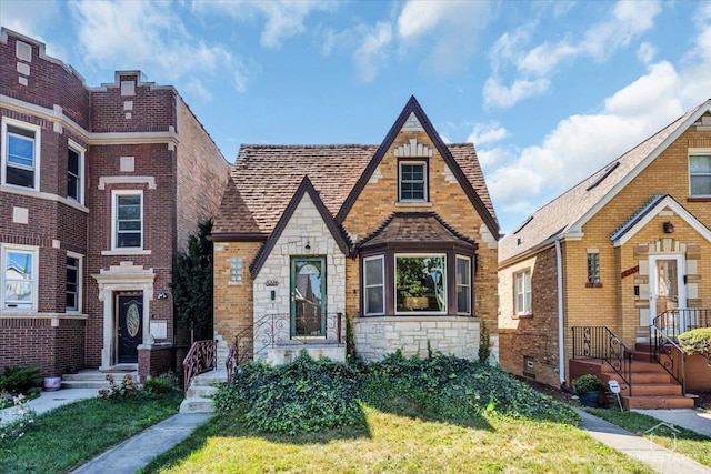 view of front of home with stone siding, brick siding, and roof with shingles