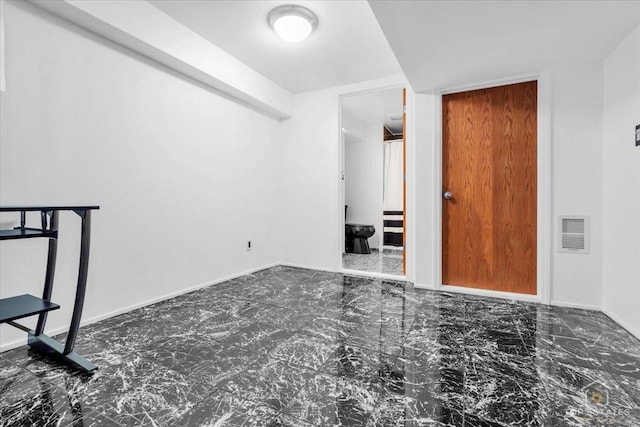 empty room featuring marble finish floor, visible vents, and baseboards