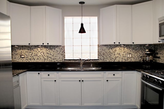 kitchen with white cabinetry, black range with gas stovetop, a sink, and fridge