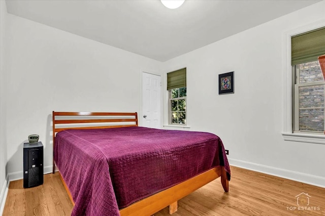 bedroom featuring baseboards and wood finished floors