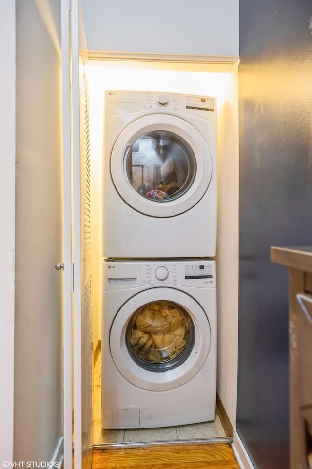 clothes washing area featuring laundry area and stacked washing maching and dryer