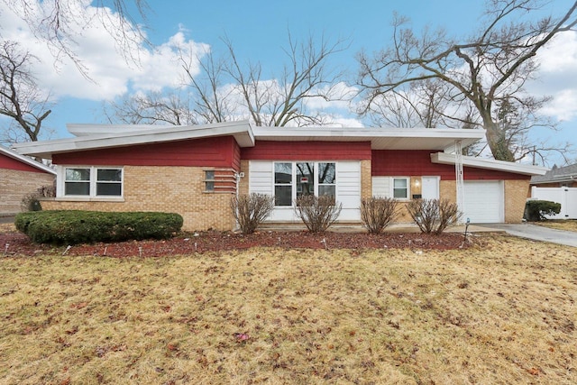 view of front facade featuring a garage, a front yard, concrete driveway, and brick siding