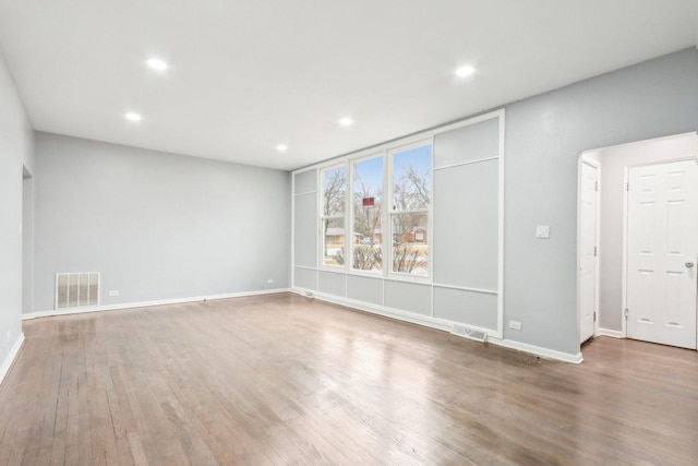 unfurnished room with baseboards, visible vents, wood finished floors, and recessed lighting