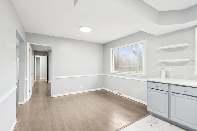 interior space featuring wood finished floors, visible vents, and baseboards