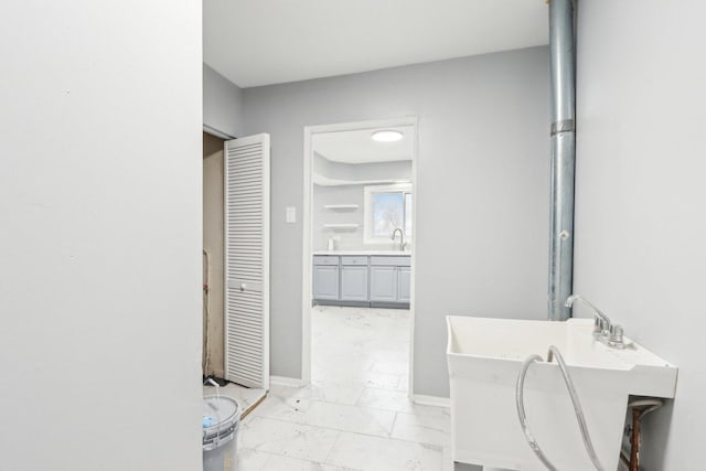 bathroom featuring marble finish floor, a freestanding tub, vanity, and baseboards