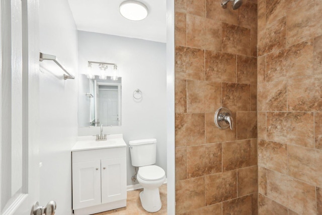 full bath with tiled shower, vanity, toilet, and baseboards