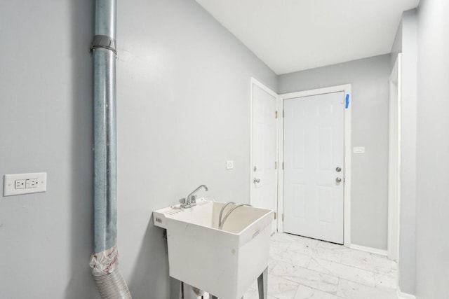 interior space with marble finish floor, baseboards, and a sink