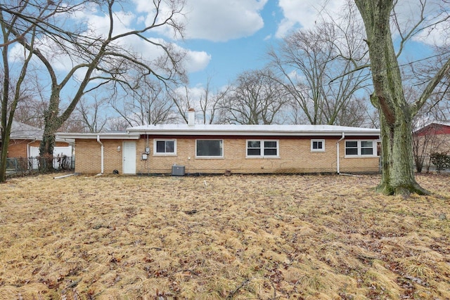 back of house with brick siding, fence, and central air condition unit