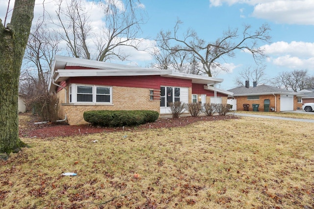 view of front of home with a garage, brick siding, and a front lawn