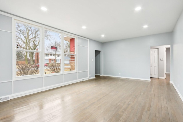 spare room with baseboards, wood finished floors, visible vents, and recessed lighting