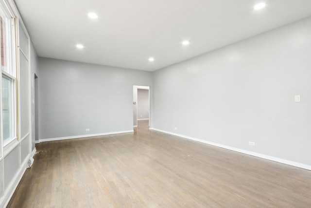 spare room with visible vents, baseboards, wood finished floors, and recessed lighting