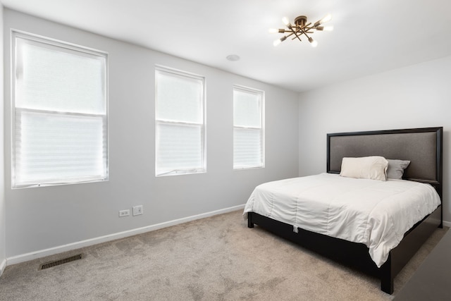 carpeted bedroom featuring visible vents and baseboards