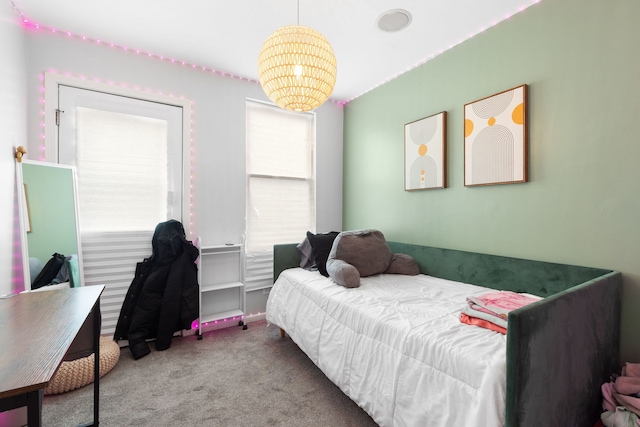 bedroom with carpet floors and an inviting chandelier