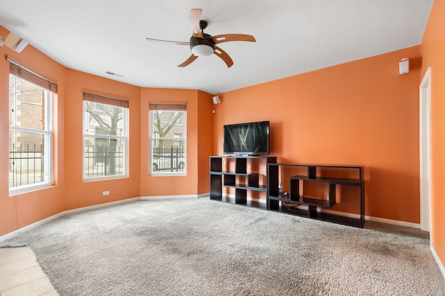 living room featuring baseboards, visible vents, and a wealth of natural light