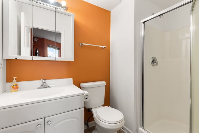 full bath with a stall shower, vanity, and toilet