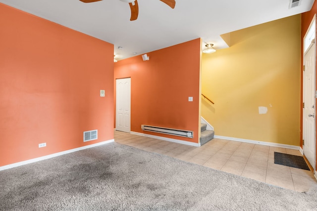 carpeted empty room with visible vents, baseboards, stairway, tile patterned flooring, and baseboard heating