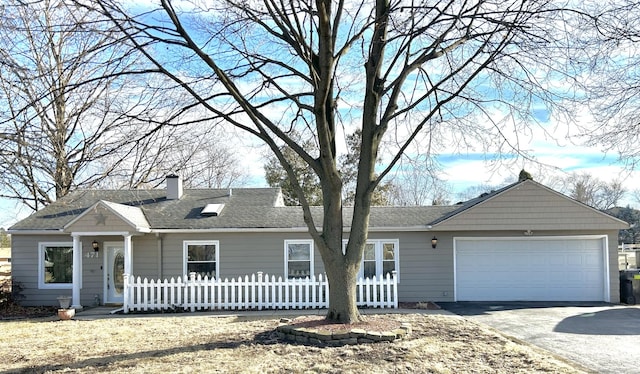 single story home with aphalt driveway, roof with shingles, a chimney, an attached garage, and fence