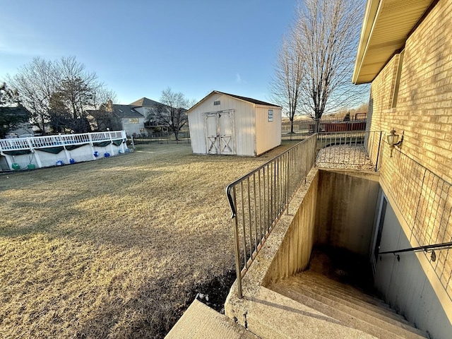 view of yard with fence, a storage unit, and an outbuilding