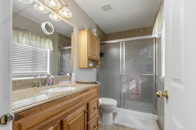 full bath with toilet, a stall shower, visible vents, and vanity