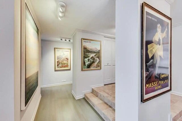 hall with light wood-type flooring and baseboards
