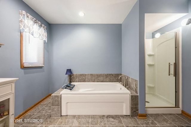 full bath featuring vanity, a garden tub, baseboards, and a stall shower