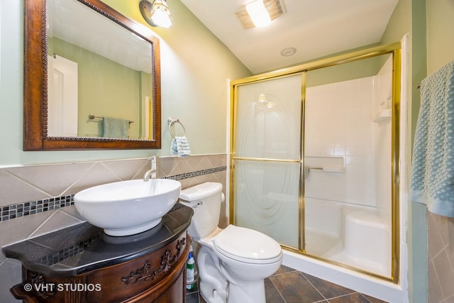 full bathroom featuring vanity, a stall shower, tile patterned flooring, tile walls, and toilet