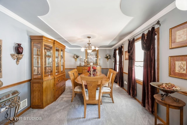 dining space featuring crown molding, a notable chandelier, visible vents, and light carpet