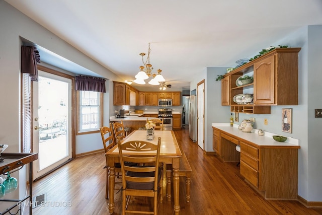 dining space with an inviting chandelier, wood finished floors, baseboards, and built in study area