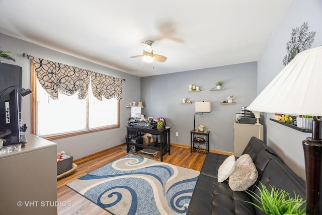 interior space with ceiling fan, baseboards, and wood finished floors